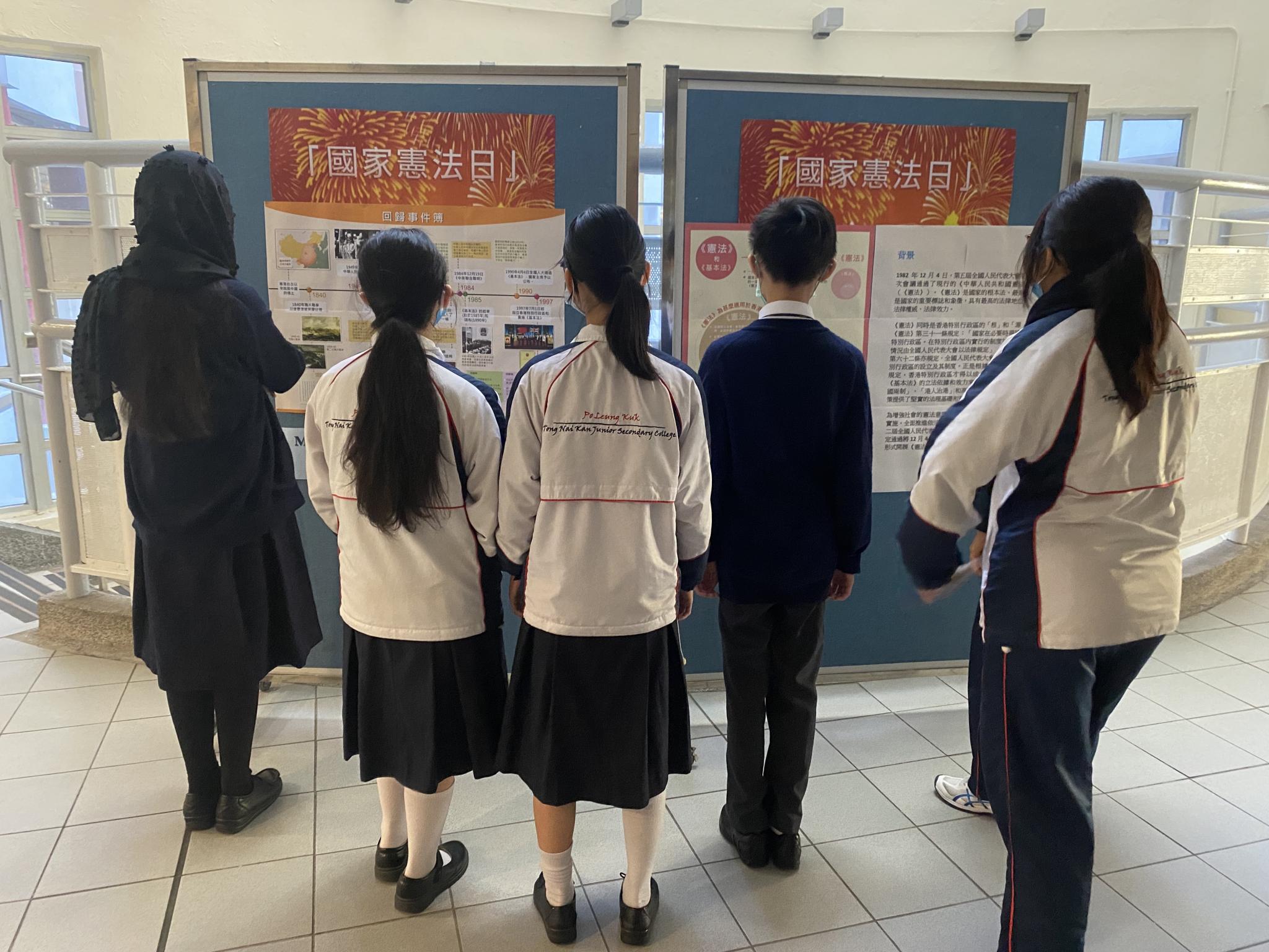 Students were reading the information on the exhibition board.