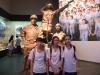 The girls are standing in front of the warrior inside the museum. 