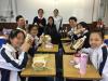 Girls from class 2B are having lunch together with their soya milk treated by Ms. Siu.