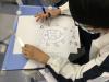 A student designing the class insignia of Class 2C and embellishing it