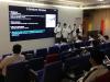 Students present their research in front of the audience in the lecture theatre.