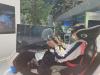 A student is experiencing the driving simulation in the Guangzhou Toyota Motor Showroom.
