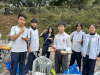 Students enjoy an outdoor barbecue while on a camping trip, bonding over good food and camaraderie in the great outdoors.