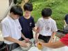 Students attempting to season the baked chicken