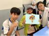 Students finish a handicraft together with the elderly.