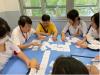 1B students are playing card game with the elderly.