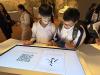 Students experience electronic Chinese calligraphy.